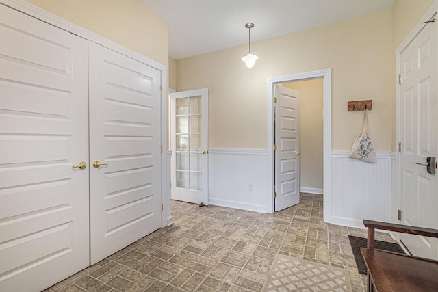 entryway featuring wainscoting and brick patterned floor