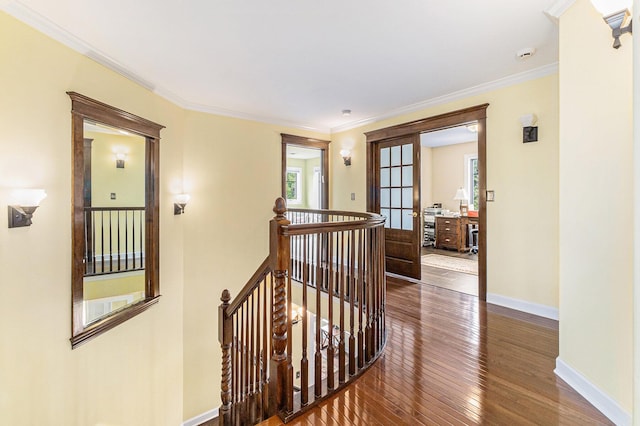 hallway featuring crown molding, hardwood / wood-style flooring, an upstairs landing, and baseboards