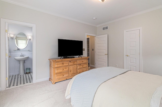 bedroom featuring light carpet, baseboards, visible vents, ensuite bathroom, and crown molding