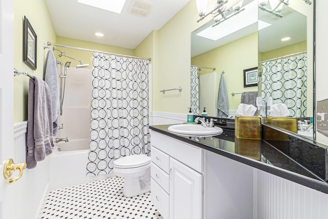 bathroom featuring shower / tub combo, a skylight, vanity, and toilet