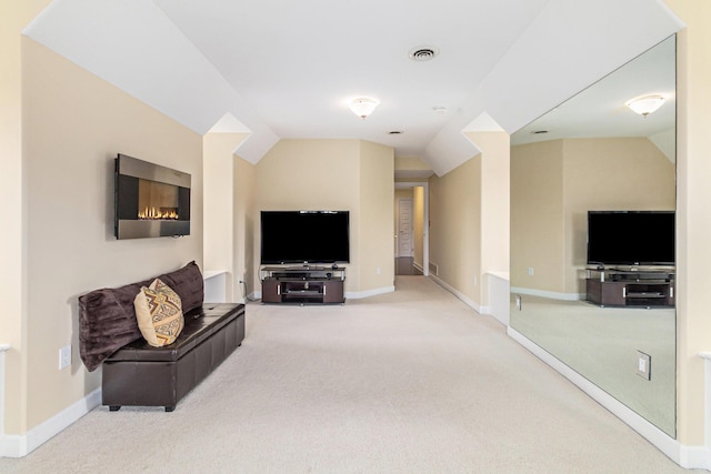 carpeted living room with lofted ceiling, visible vents, and baseboards