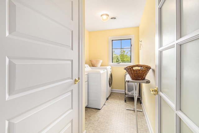 laundry area with laundry area, washing machine and dryer, visible vents, and baseboards