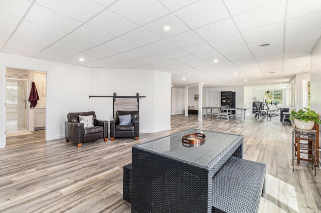 living room featuring light wood-type flooring, a drop ceiling, and recessed lighting