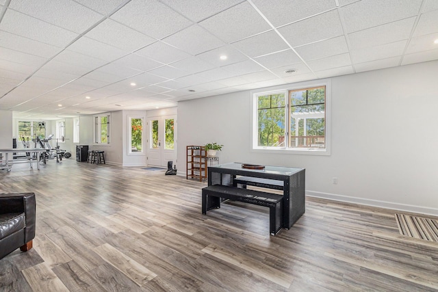 interior space with a drop ceiling, recessed lighting, wood finished floors, visible vents, and baseboards