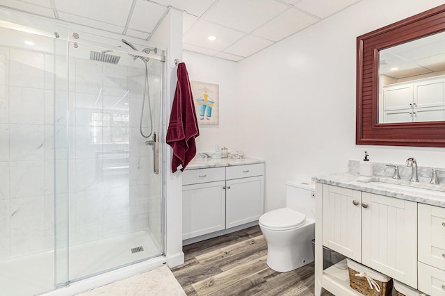 full bathroom featuring visible vents, toilet, wood finished floors, vanity, and a shower stall