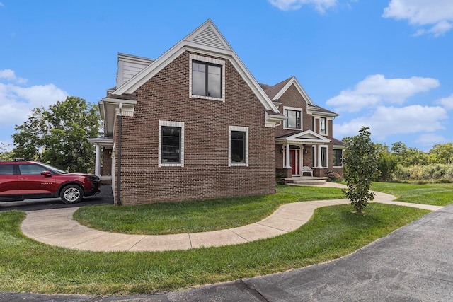 view of front of home with brick siding and a front yard