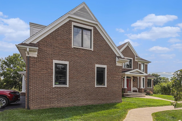 view of side of home featuring brick siding and a yard