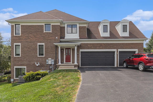 view of front of house featuring central AC unit, brick siding, a shingled roof, driveway, and a front lawn