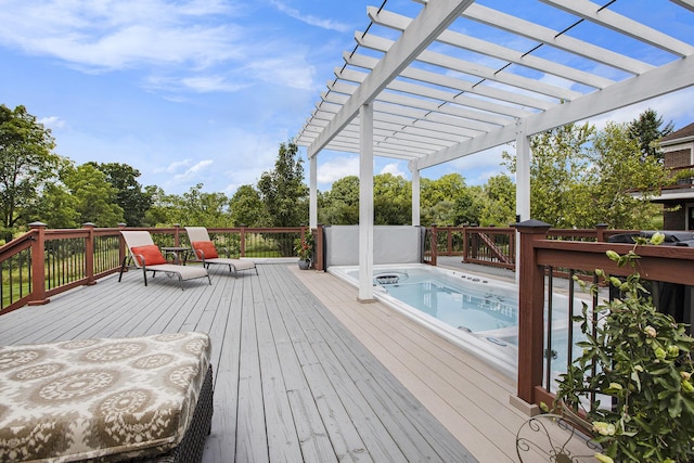 deck featuring hot tub deck surround and a pergola