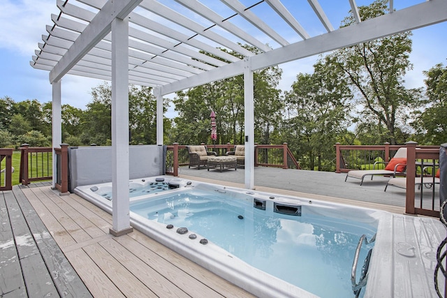 deck featuring hot tub deck surround and a pergola