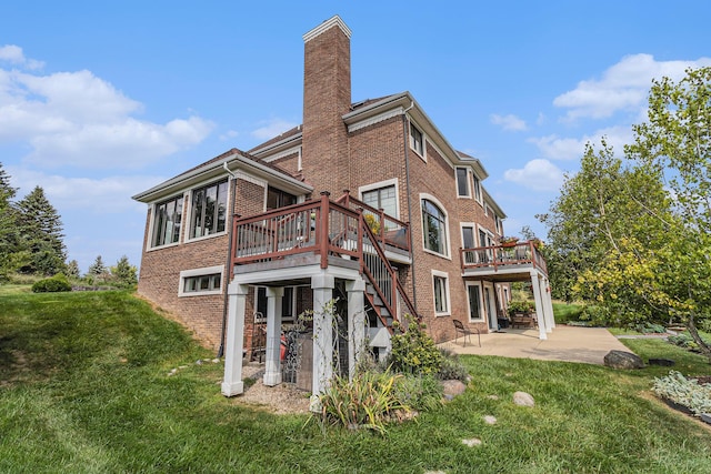 rear view of property with a lawn, a chimney, stairs, a patio area, and brick siding