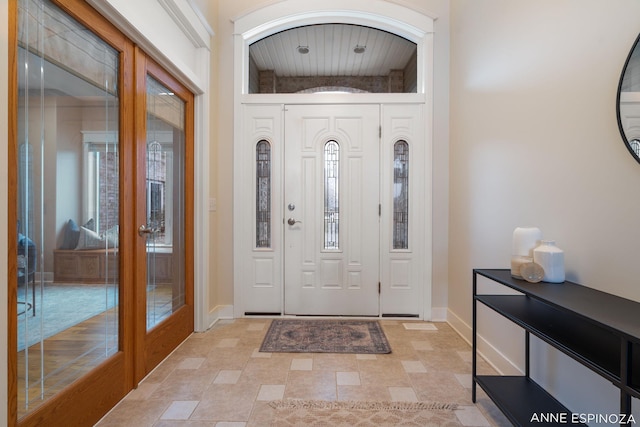 foyer entrance with baseboards and french doors