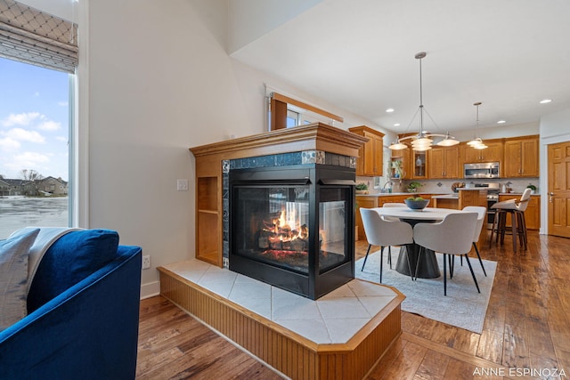 living room featuring a fireplace, dark wood-type flooring, and recessed lighting