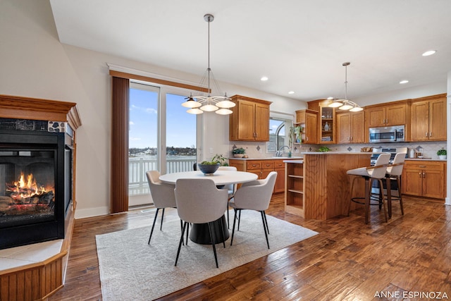 dining area featuring recessed lighting, dark wood finished floors, baseboards, and a premium fireplace