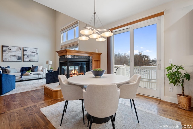 dining area featuring baseboards, hardwood / wood-style floors, and a multi sided fireplace