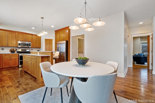 dining space featuring recessed lighting, baseboards, and wood finished floors