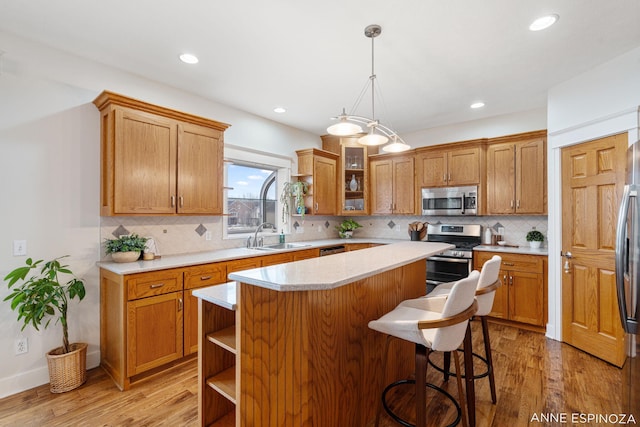 kitchen featuring appliances with stainless steel finishes, open shelves, a sink, and light countertops