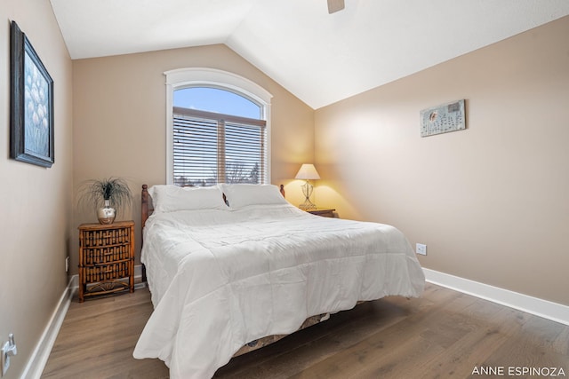 bedroom featuring a ceiling fan, baseboards, vaulted ceiling, and wood finished floors