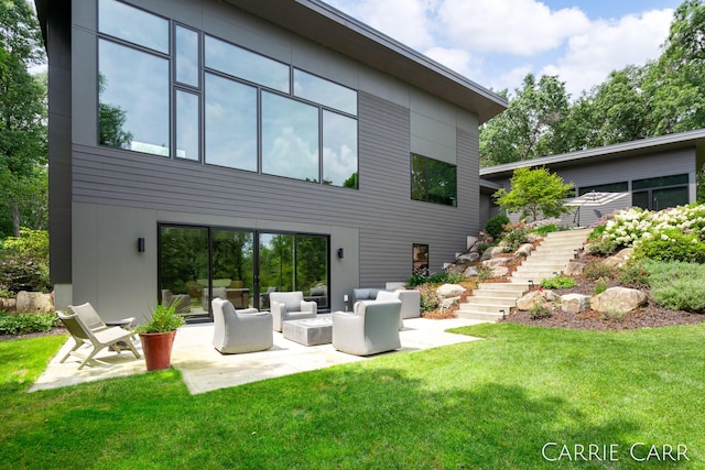 rear view of house featuring a yard, stairs, an outdoor hangout area, and a patio