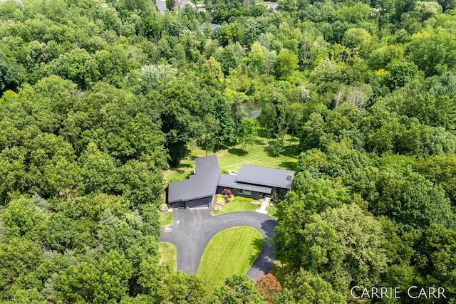 bird's eye view with a wooded view