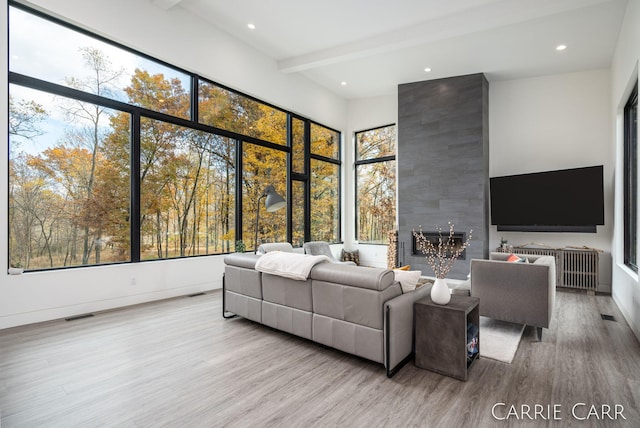 living area featuring recessed lighting, visible vents, beam ceiling, and wood finished floors