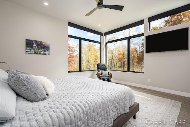 bedroom featuring a ceiling fan, baseboards, wood finished floors, and recessed lighting