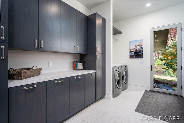 washroom featuring recessed lighting, separate washer and dryer, baseboards, light wood-style floors, and cabinet space