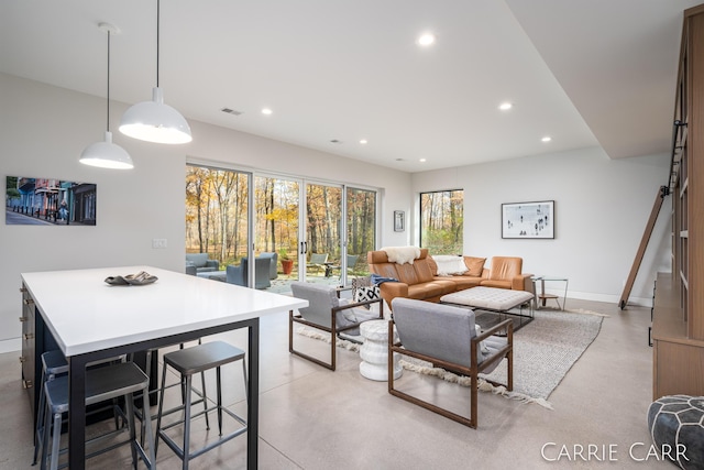 living room with baseboards, concrete floors, visible vents, and recessed lighting