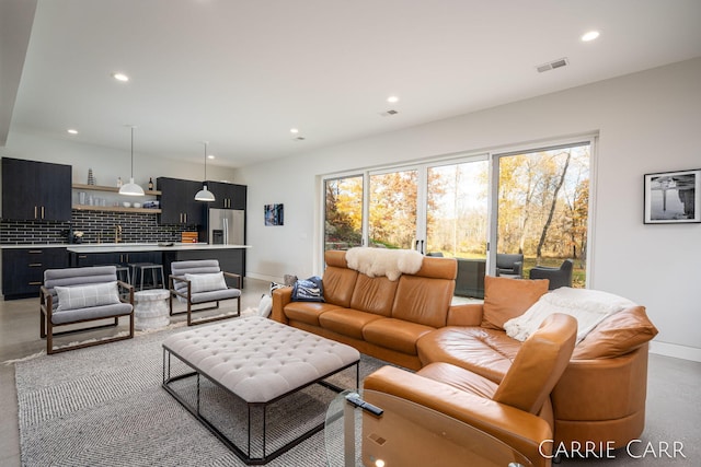 living area with baseboards, visible vents, and recessed lighting