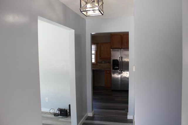 hallway featuring dark wood-type flooring and baseboards