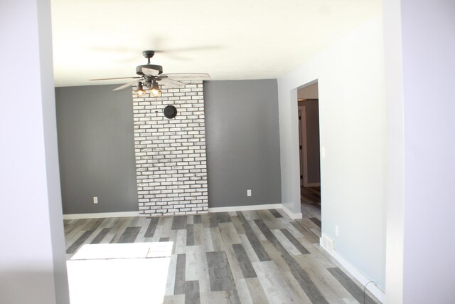 unfurnished room featuring ceiling fan, wood finished floors, and baseboards