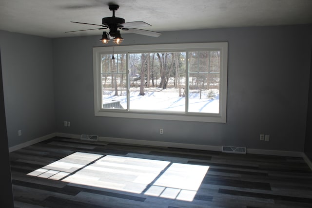 empty room featuring visible vents, baseboards, and wood finished floors