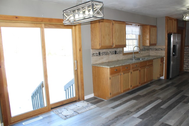 kitchen with light wood-type flooring, visible vents, and stainless steel fridge with ice dispenser