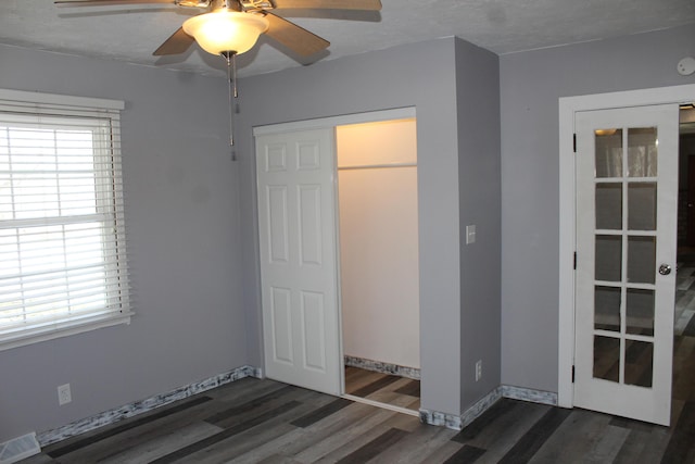 unfurnished bedroom featuring wood finished floors, visible vents, baseboards, and multiple windows