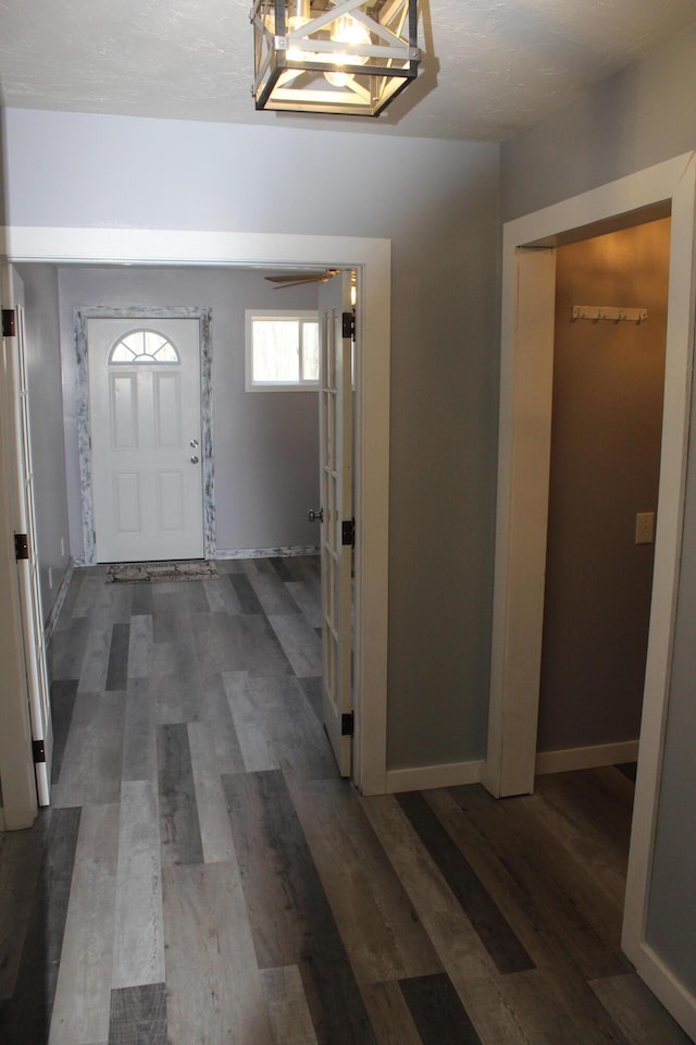 entrance foyer with a textured ceiling, baseboards, and wood finished floors