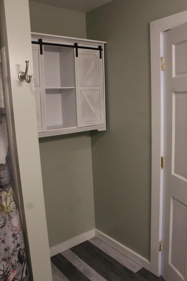 bathroom with baseboards and wood finished floors