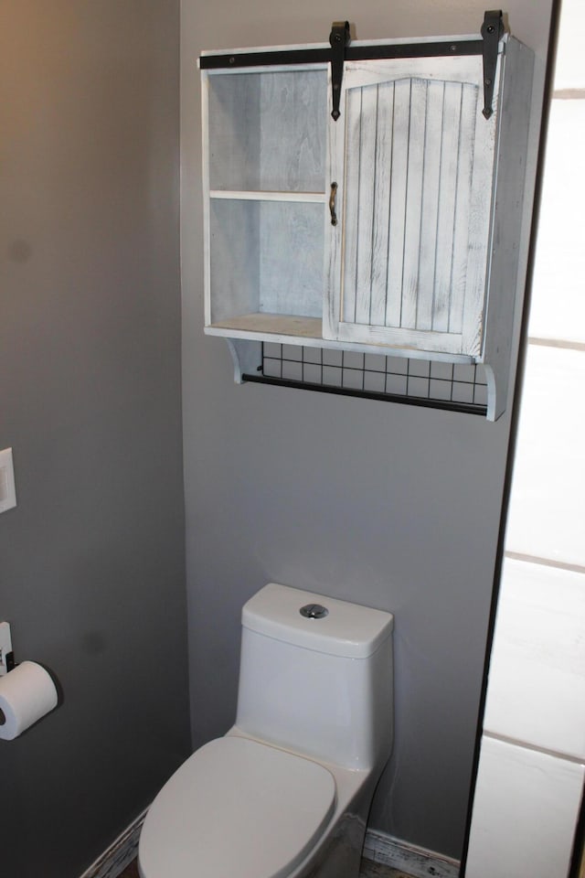 bathroom featuring toilet and baseboards