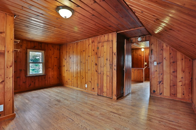 bonus room with wood ceiling, wooden walls, and wood finished floors