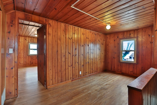 interior space with wooden ceiling, baseboards, and wood finished floors