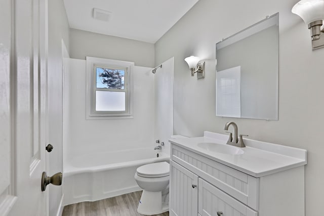 bathroom featuring vanity, bathing tub / shower combination, wood finished floors, and toilet