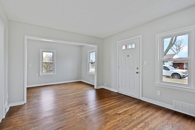 entrance foyer with visible vents, baseboards, and wood finished floors