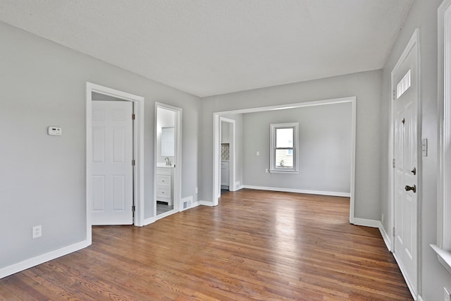 unfurnished room with visible vents, baseboards, and wood finished floors