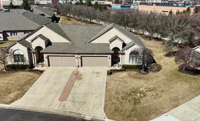 view of front of house featuring brick siding, a shingled roof, a front lawn, a garage, and driveway