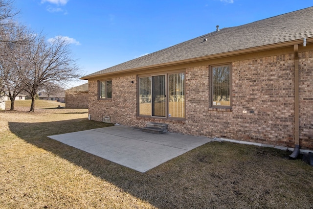 rear view of property with brick siding, entry steps, roof with shingles, a yard, and a patio