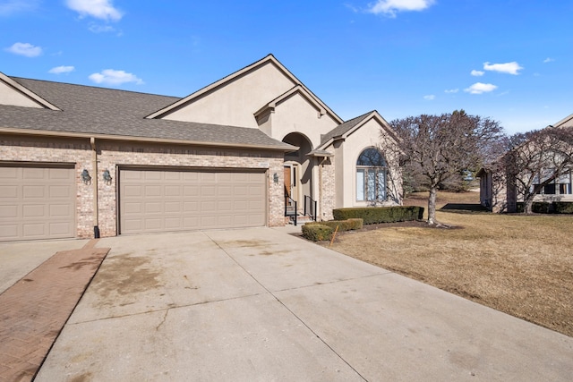 view of front of house featuring stucco siding, a front lawn, driveway, roof with shingles, and an attached garage