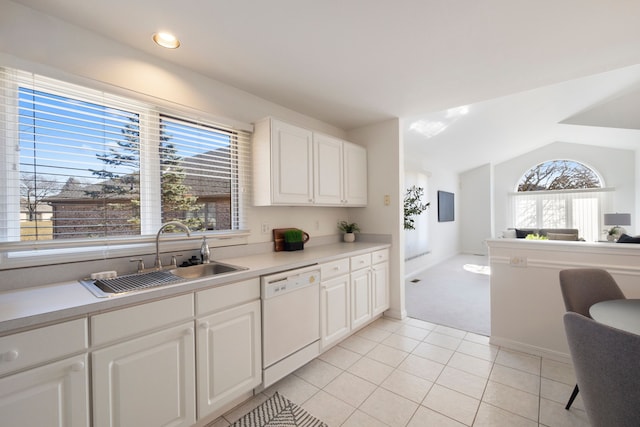 kitchen with a sink, a healthy amount of sunlight, light tile patterned flooring, and white dishwasher