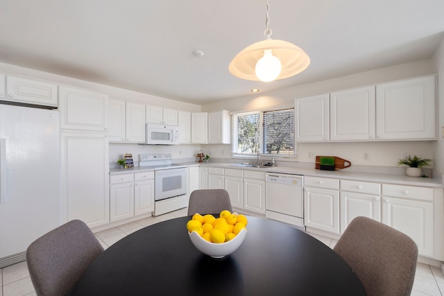 kitchen with light tile patterned floors, white cabinets, white appliances, and a sink