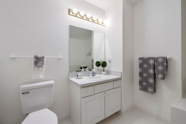 bathroom featuring baseboards, toilet, and vanity