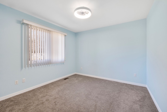 carpeted empty room with visible vents and baseboards