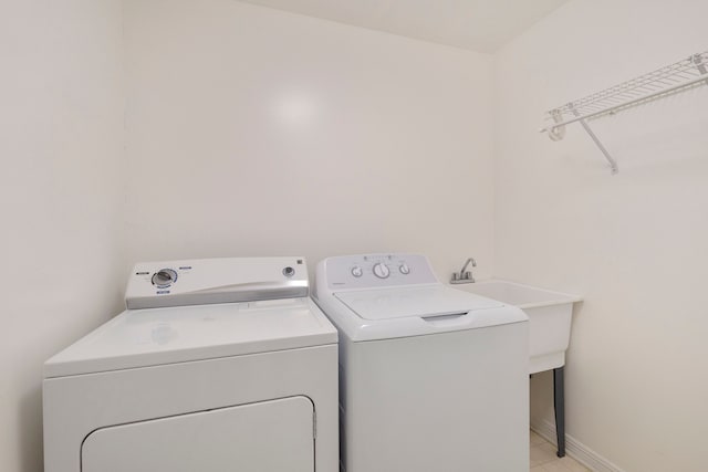 laundry room featuring laundry area, baseboards, and separate washer and dryer